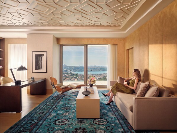 Una sala de estar moderna con un ventanal grande, una mesa de centro, un sofá y un escritorio con una lámpara.