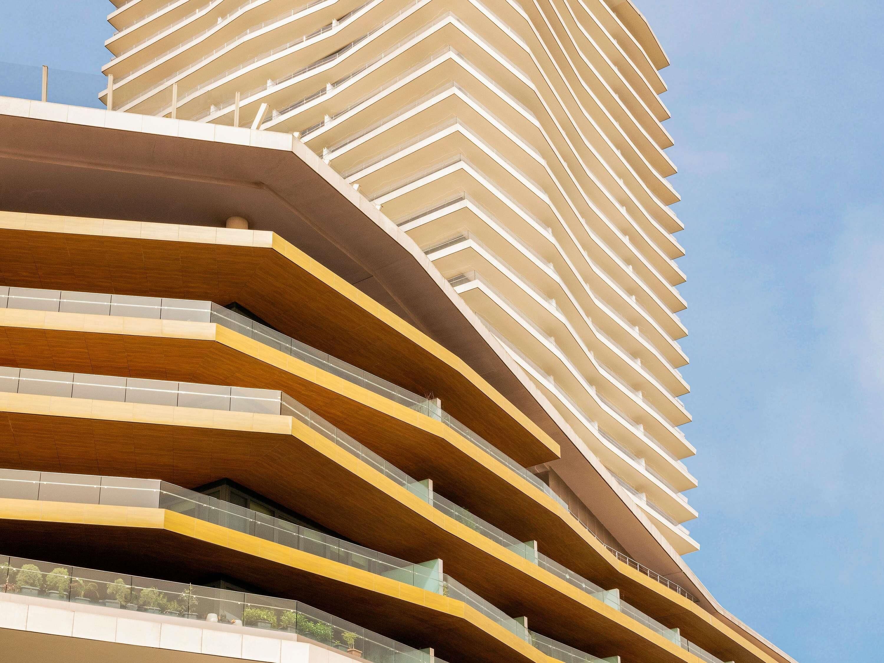 Een modern gebouw met meerdere balkons en een gebogen gevel.