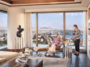 A spacious room with a large window offering a city view, a comfortable seating area, and a modern interior design. - Raffles Istanbul (Istanbul)