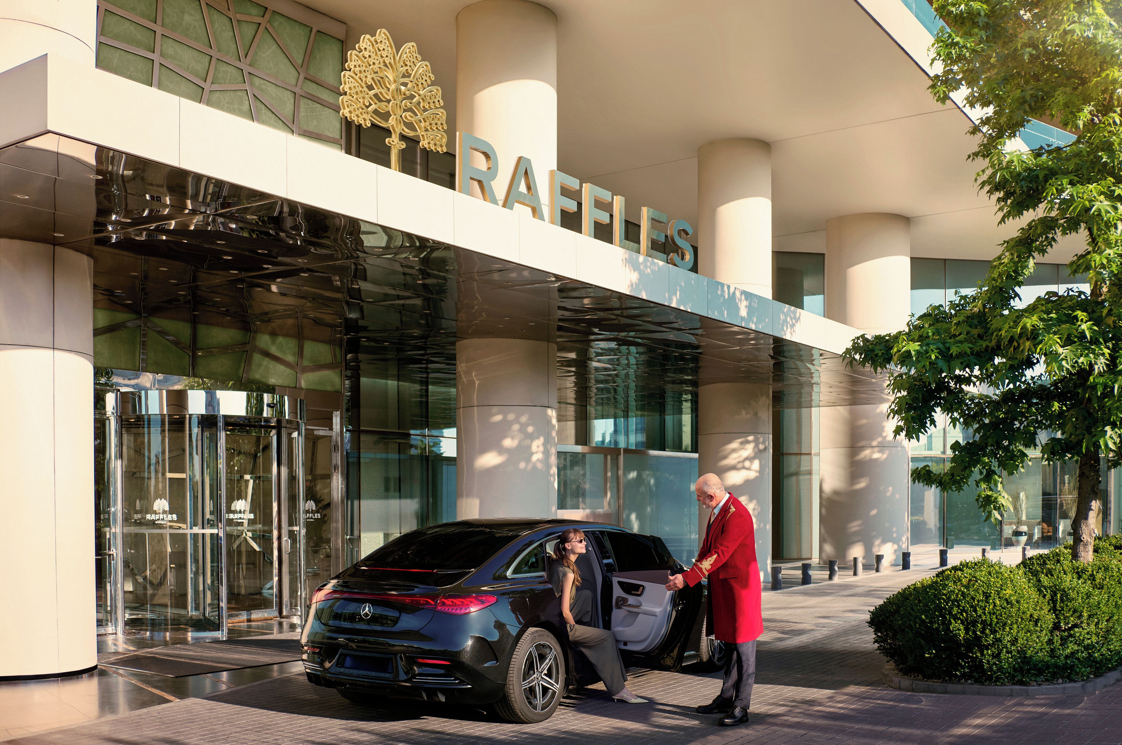 Een modern gebouw met een glazen gevel en de tekst 'RAFFLES' duidelijk zichtbaar.