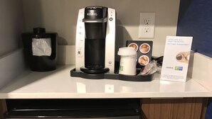 A compact refrigerator with a Danby logo, a Keurig coffee maker, a tissue dispenser, and a coffee pod holder.
