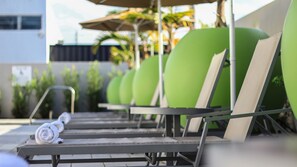 A row of green lounge chairs with a towel on one. - Holiday Inn Express & Suites Miami Airport East by IHG (Miami)