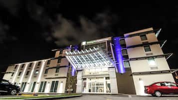 A hotel with a modern design, featuring a prominent entrance with a glass canopy and a sign for Holiday Inn Express & Suites.