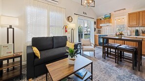 A modern living room with a sofa, coffee table, and a dining area with a bench. - Castlewood Inn (Maggie Valley)