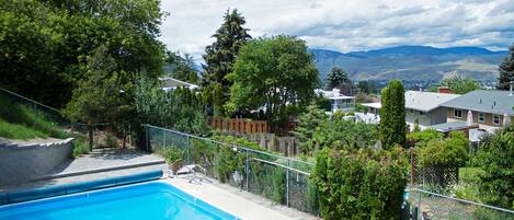 A swimming pool with a view of houses and mountains in the background.