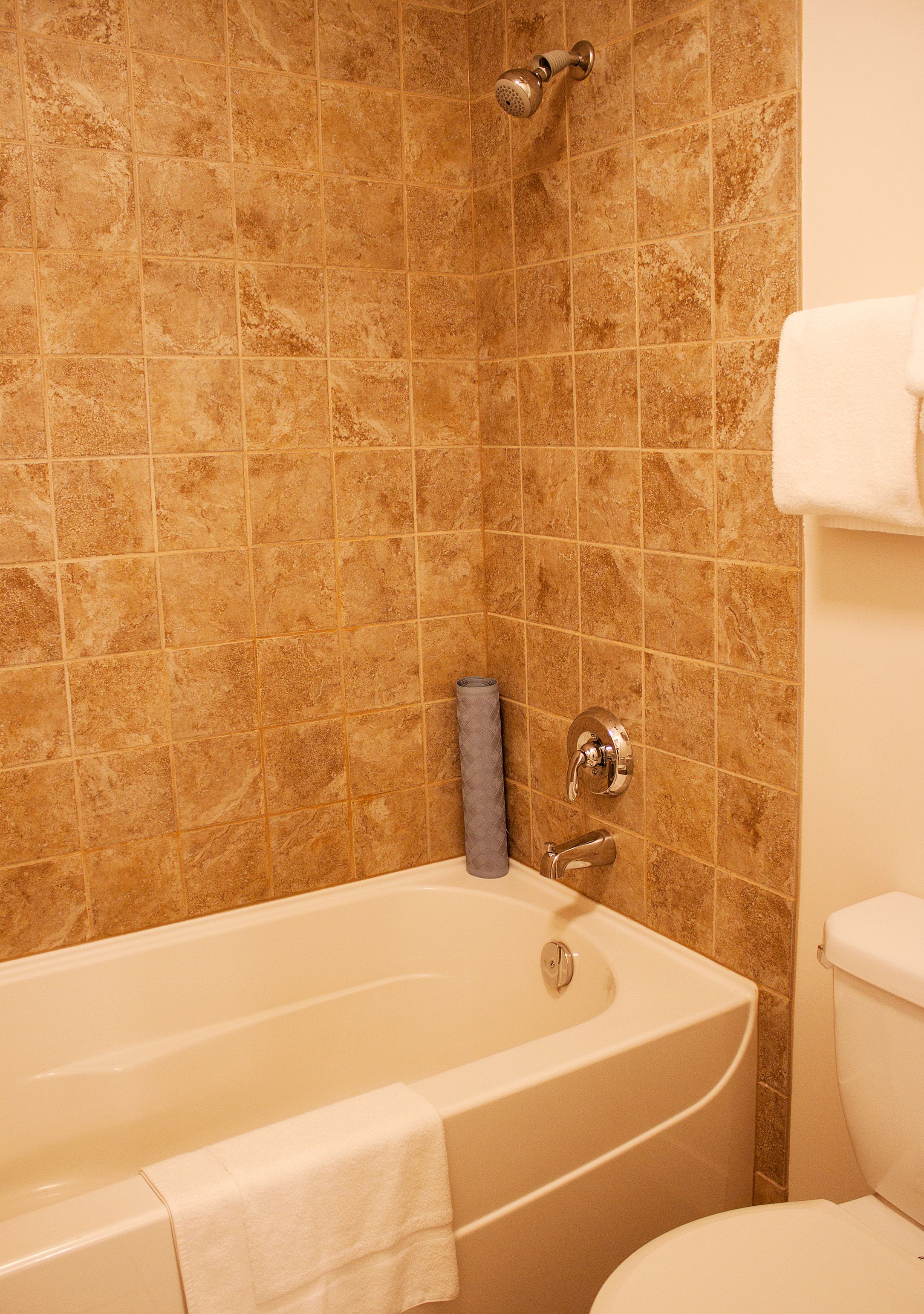 A bathroom with a bathtub, a toilet, and a showerhead.