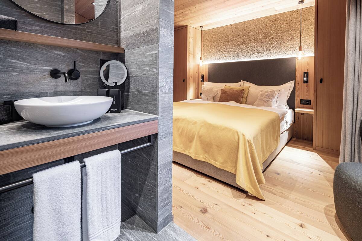 Ein modernes Badezimmer mit einem großen Waschbecken, einem Spiegel und einem Handtuchhalter.