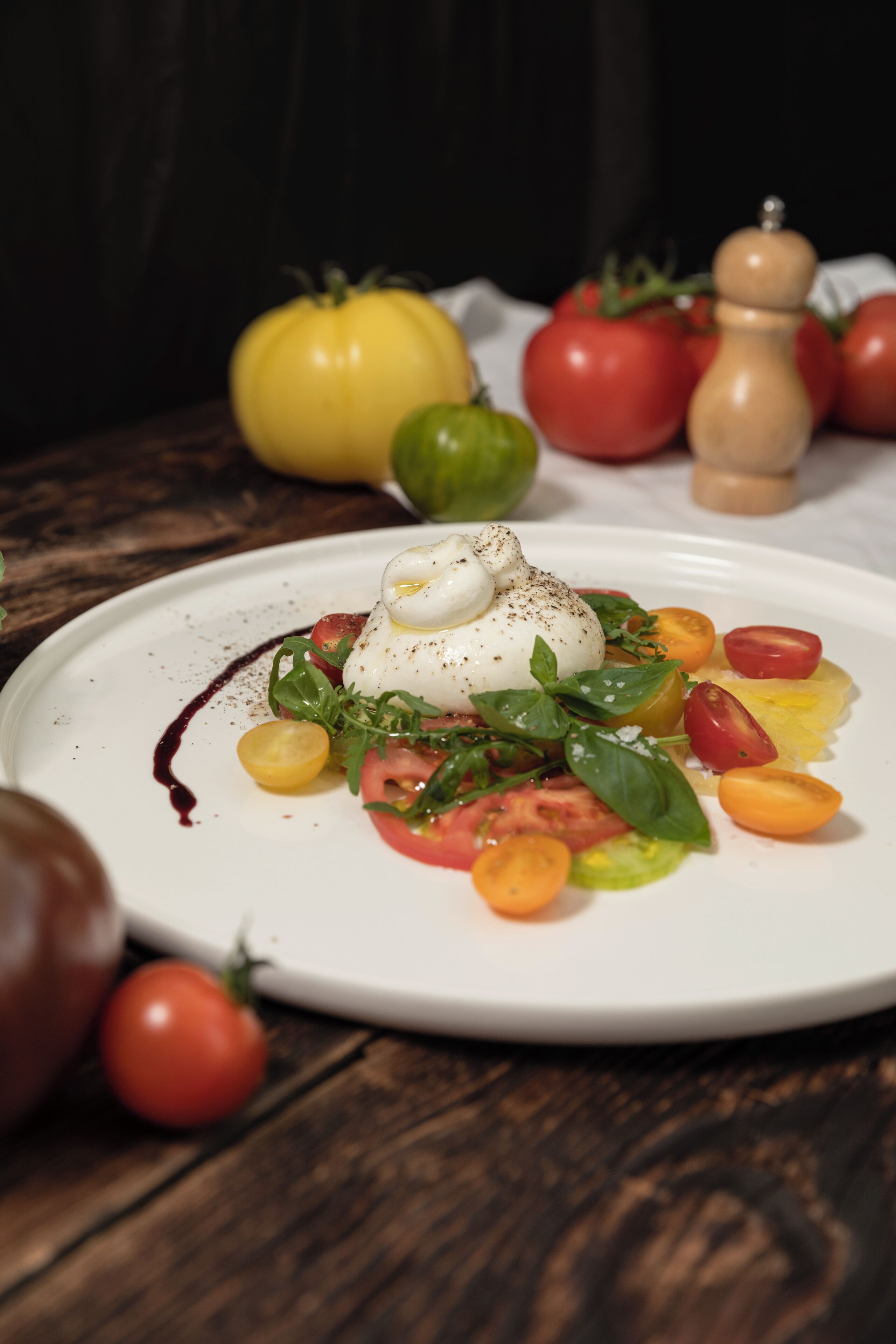 Prato com ovo pochê, tomates e folhas verdes.