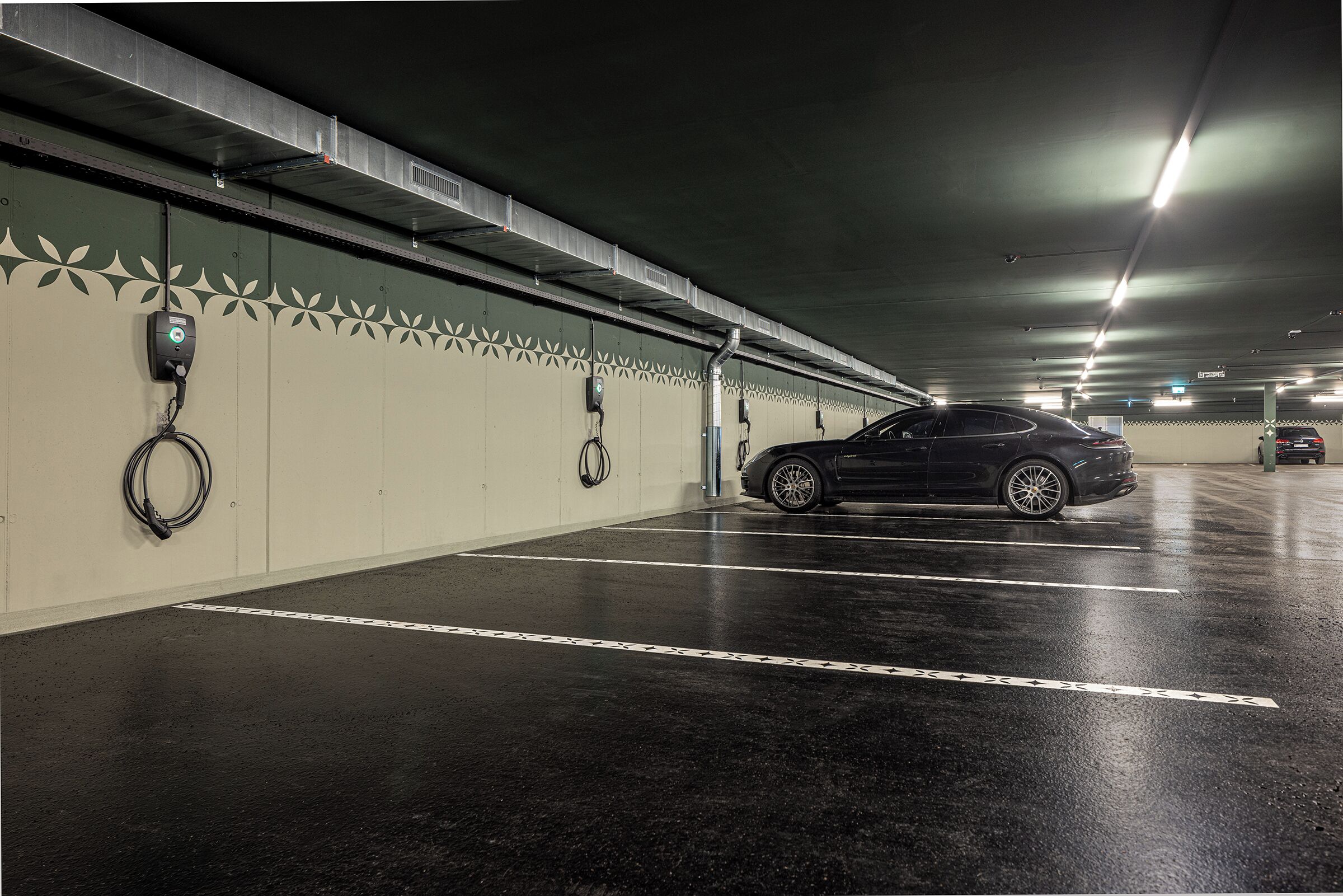 Un garaje para estacionar con un coche negro en un lugar.