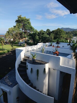 A white building with a curved staircase, outdoor seating, and potted plants. - Keereeta Resort & Spa (Ko Chang)