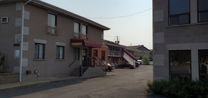 A building with a reception area, a staircase, and a parking lot with cars.