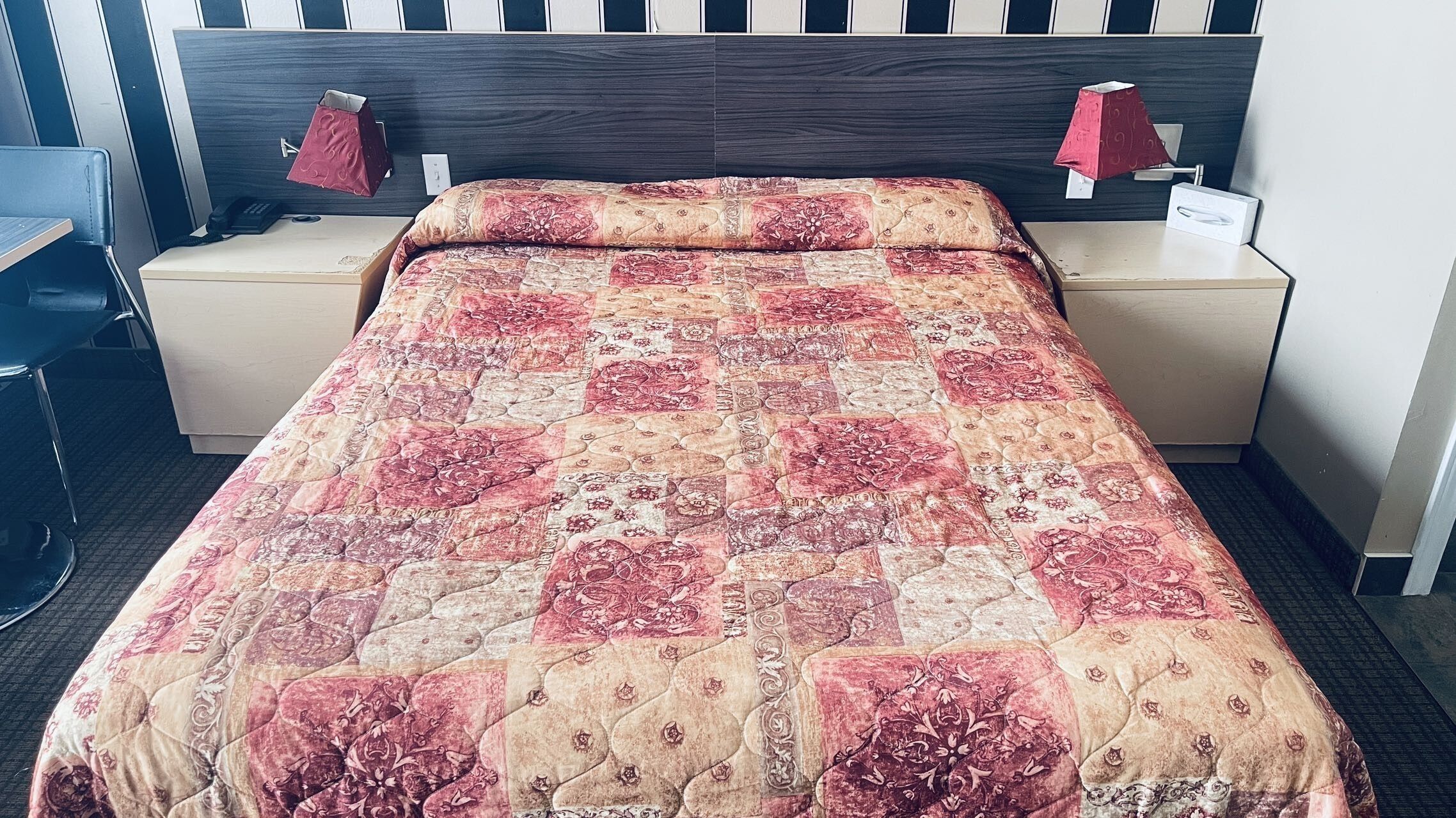 Una habitación de hotel con una cama grande, dos mesitas de noche y un escritorio.