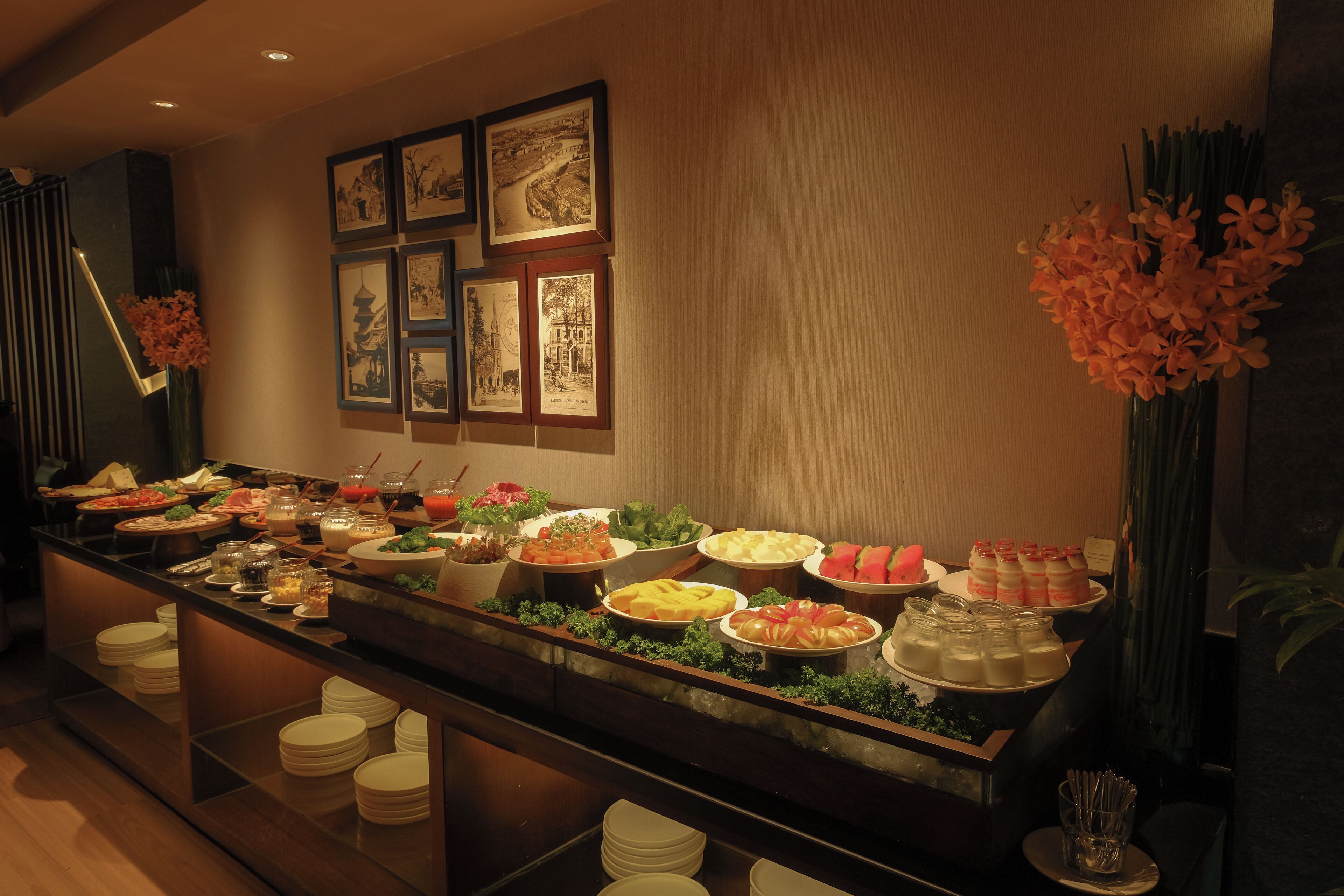 A buffet with various dishes and a wall decorated with framed pictures.