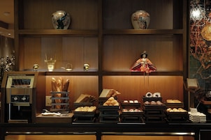 A bakery display with various baked goods and a decorative figure.