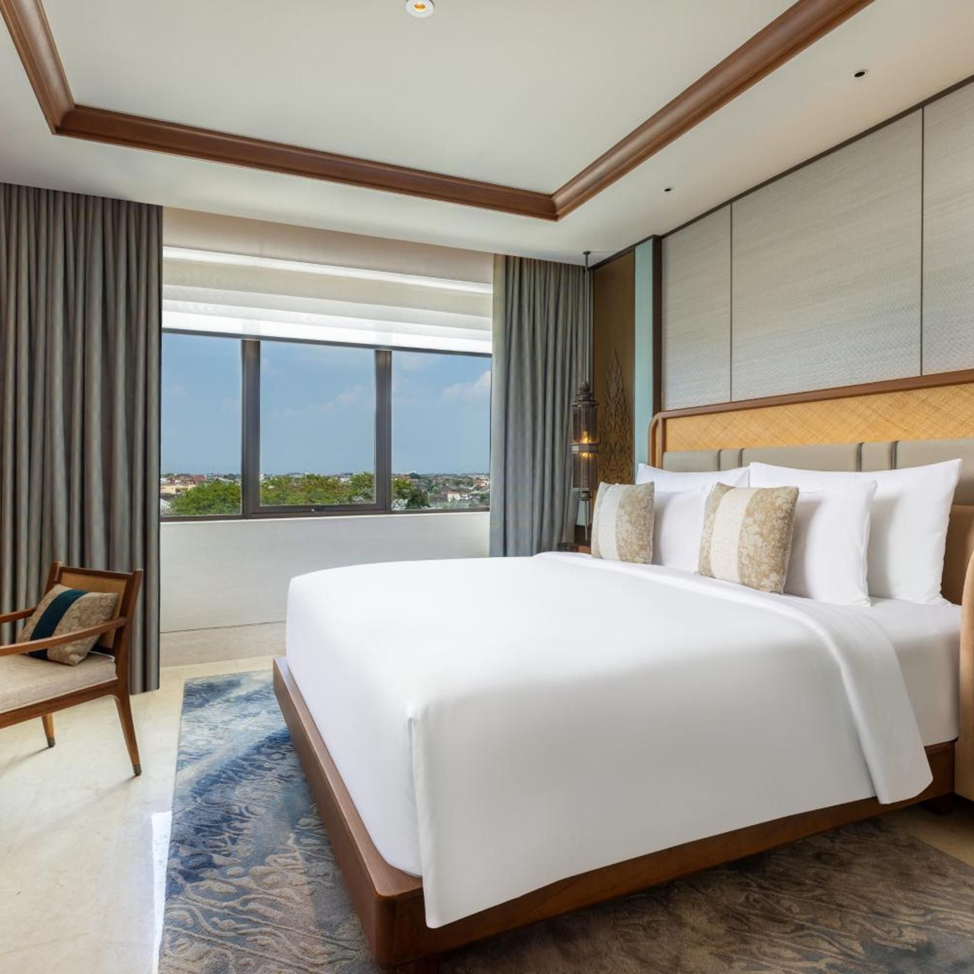 A hotel room with a large bed, a view of the city, and a modern design.