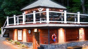 A wooden building with a balcony, a clock, and a lifebuoy. - The Juliana Resort (Diamond Point)