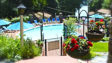A pool area with lounge chairs and a sign indicating pool rules.