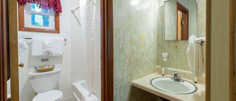 Un baño con inodoro, bañera y lavamanos.
