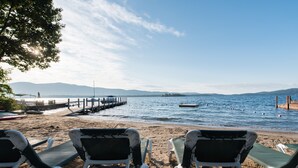A beach with white lounge chairs and a pier extending into the water. - The Juliana Resort (Diamond Point)