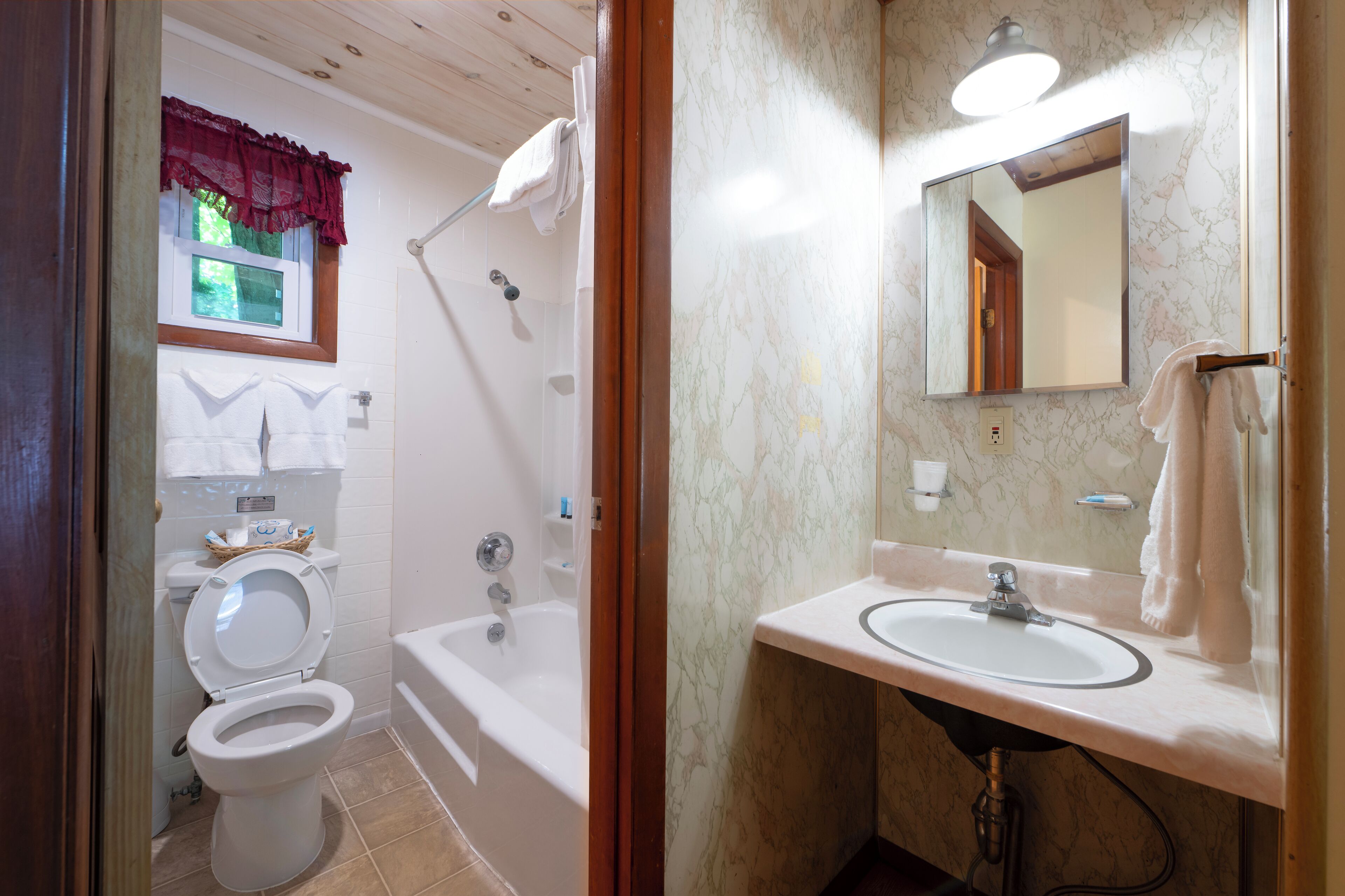 A bathroom with a toilet, bathtub, and sink.