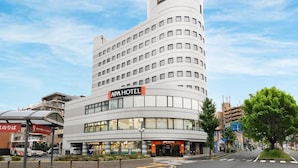 Ein modernes Hotel mit geschwungener Fassade, mehreren Etagen und einer auffälligen Beschilderung.