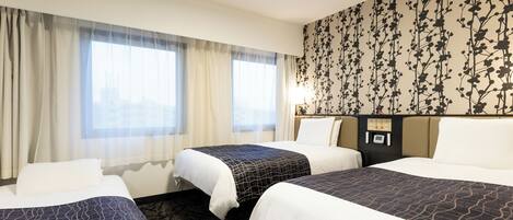 A hotel room with two beds, a large window with sheer curtains, a floral wallpaper, and a control panel on the wall.