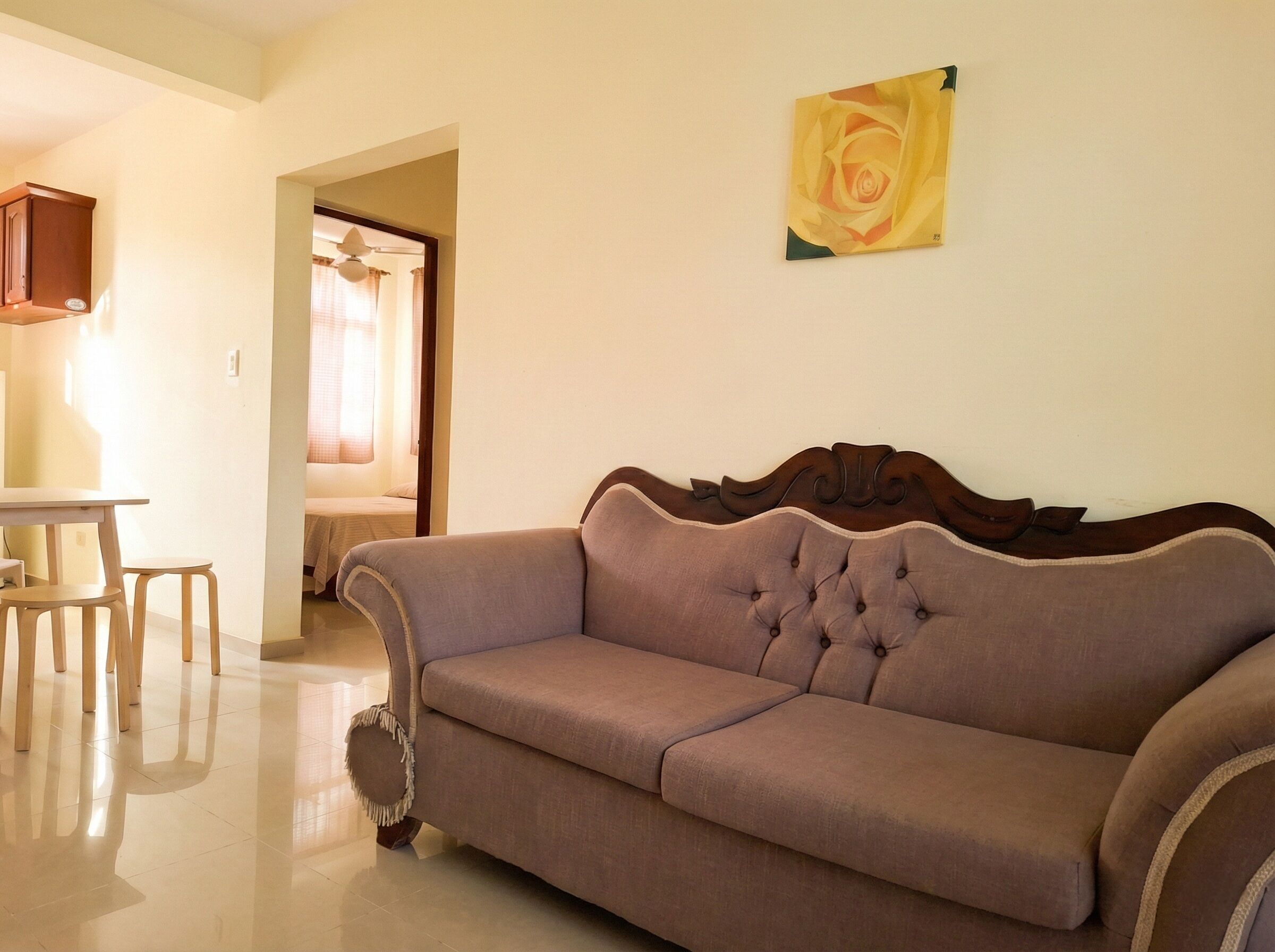A living room with a brown sofa, wooden table, and chairs.