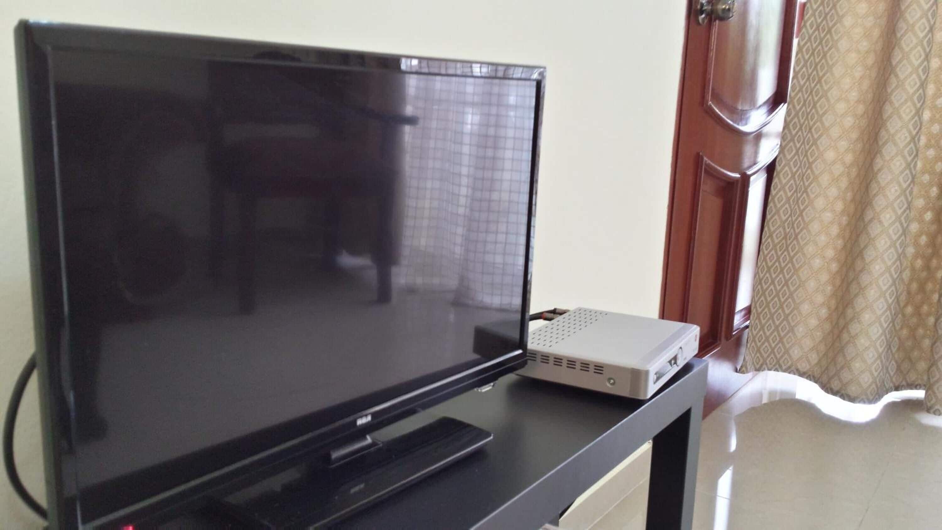 A flat-screen TV on a stand with a DVD player beside it.