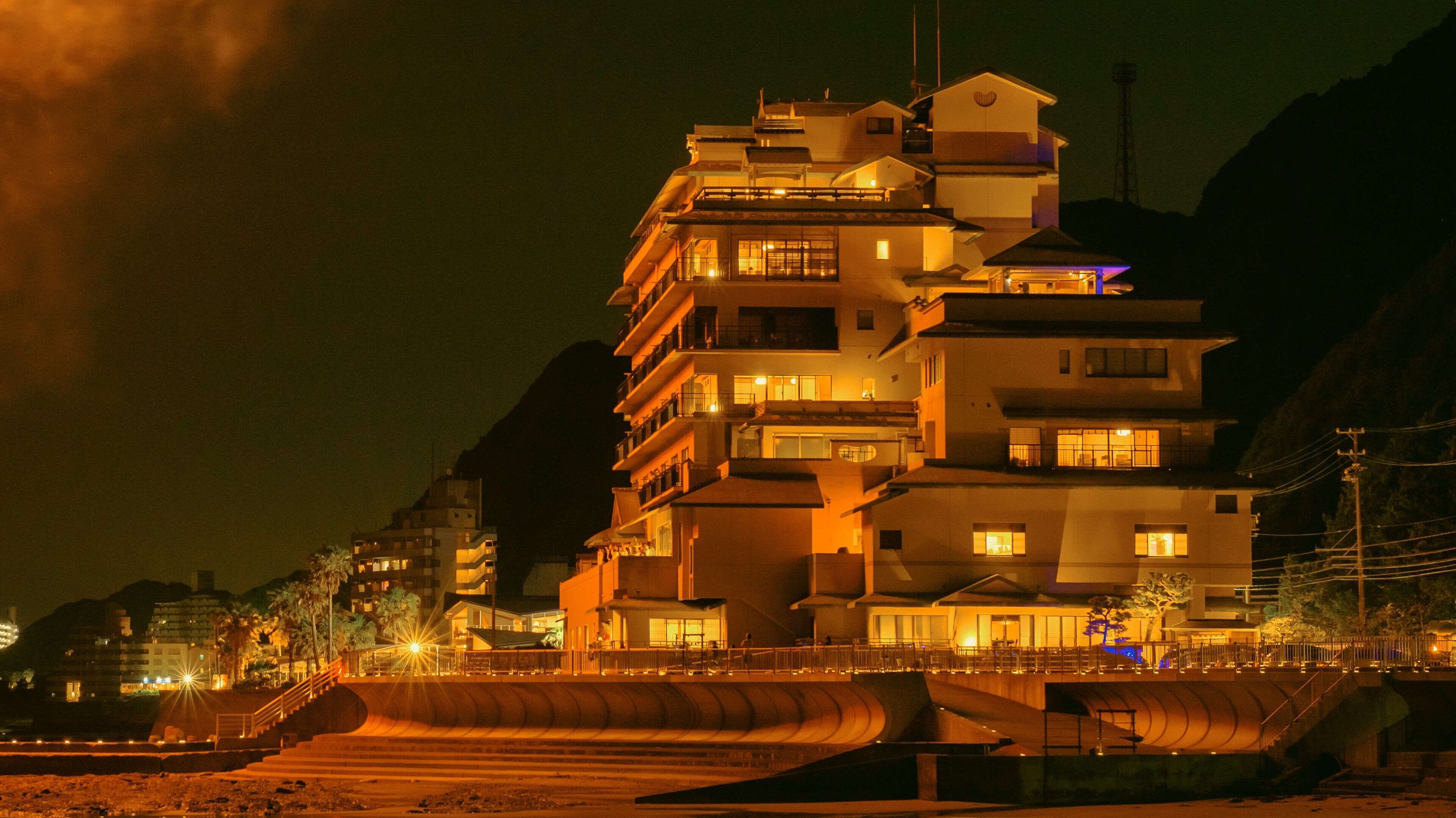 A multi-story hotel with balconies and a curved ramp leading to the entrance.