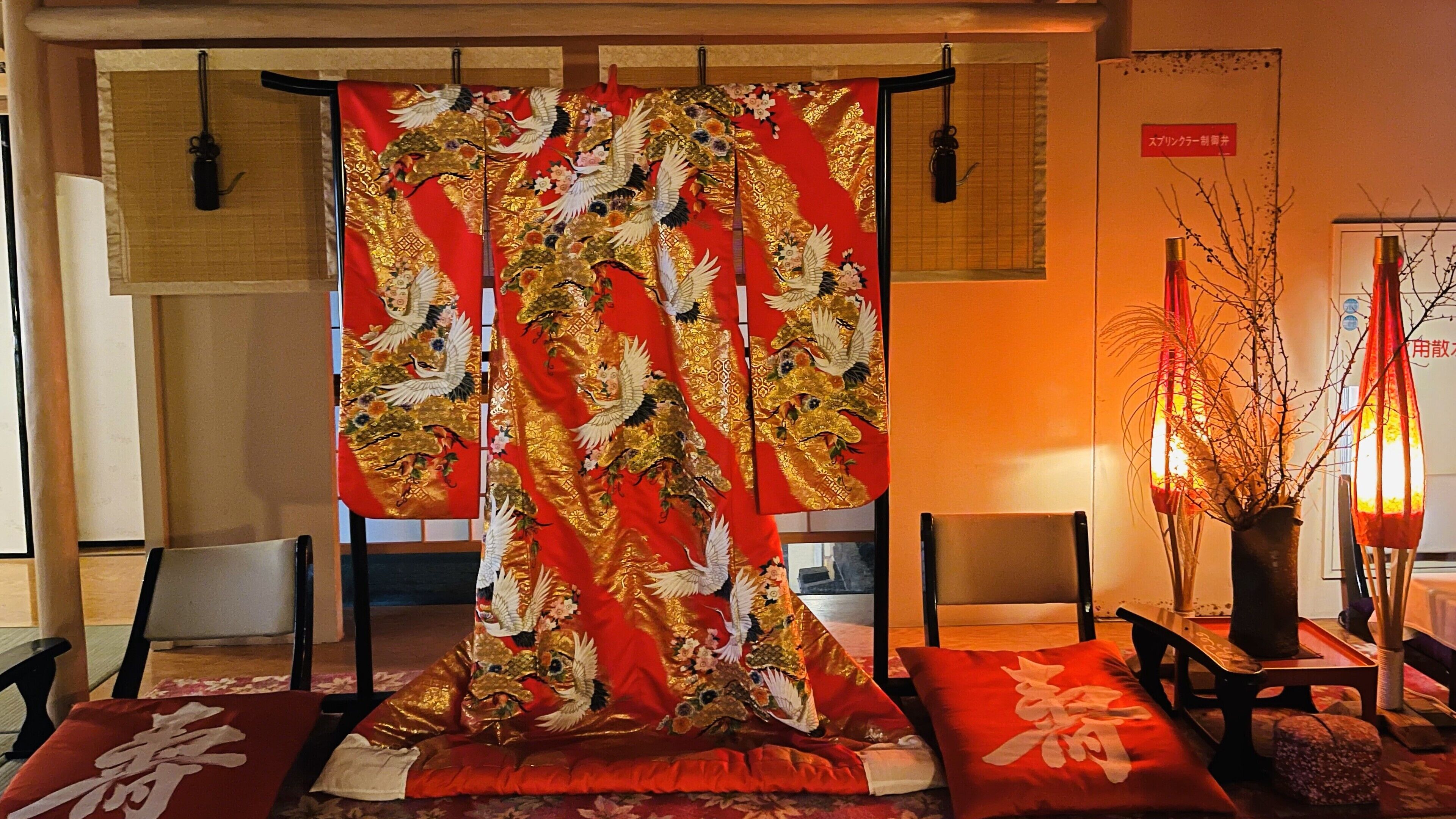 A traditional Japanese room with tatami flooring, a shoji screen, and a low table with cushions.