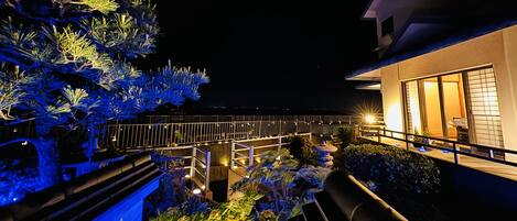 A night view of a building with a balcony, illuminated by artificial lighting.