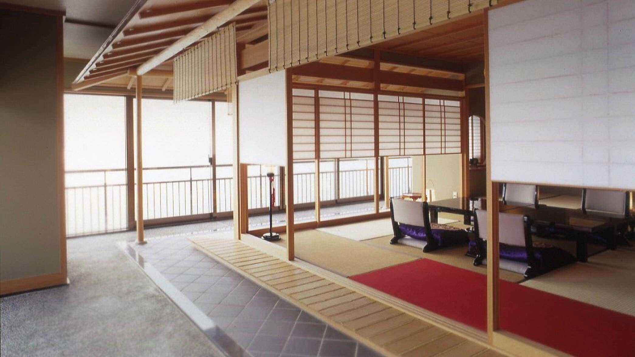 Une pièce de style japonais traditionnel, avec un sol recouvert de tatamis, des portes coulissantes et un plafond bas en bois.