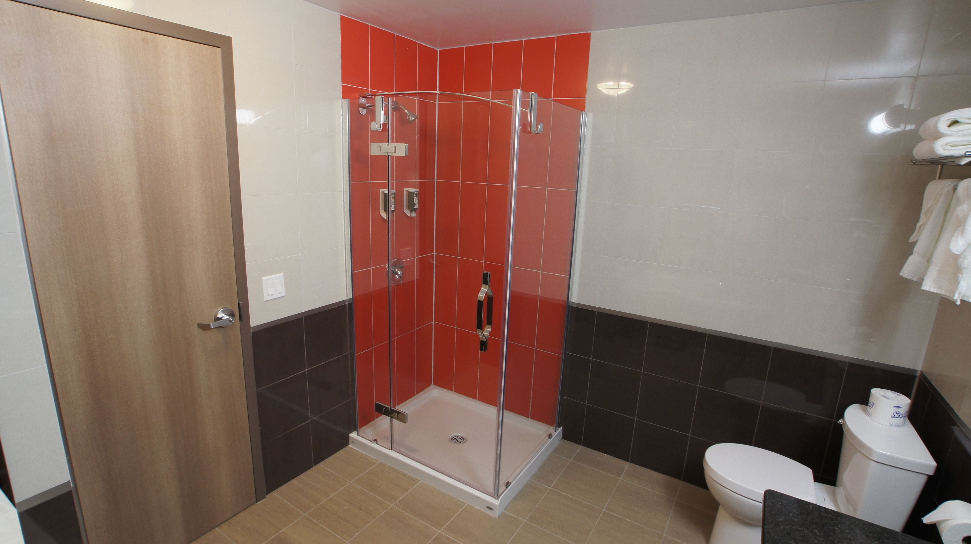 Een badkamer met een douchecabine, toilet en wastafel.