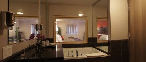 Een moderne badkamer met een grote spiegel, een bad en een wastafel.