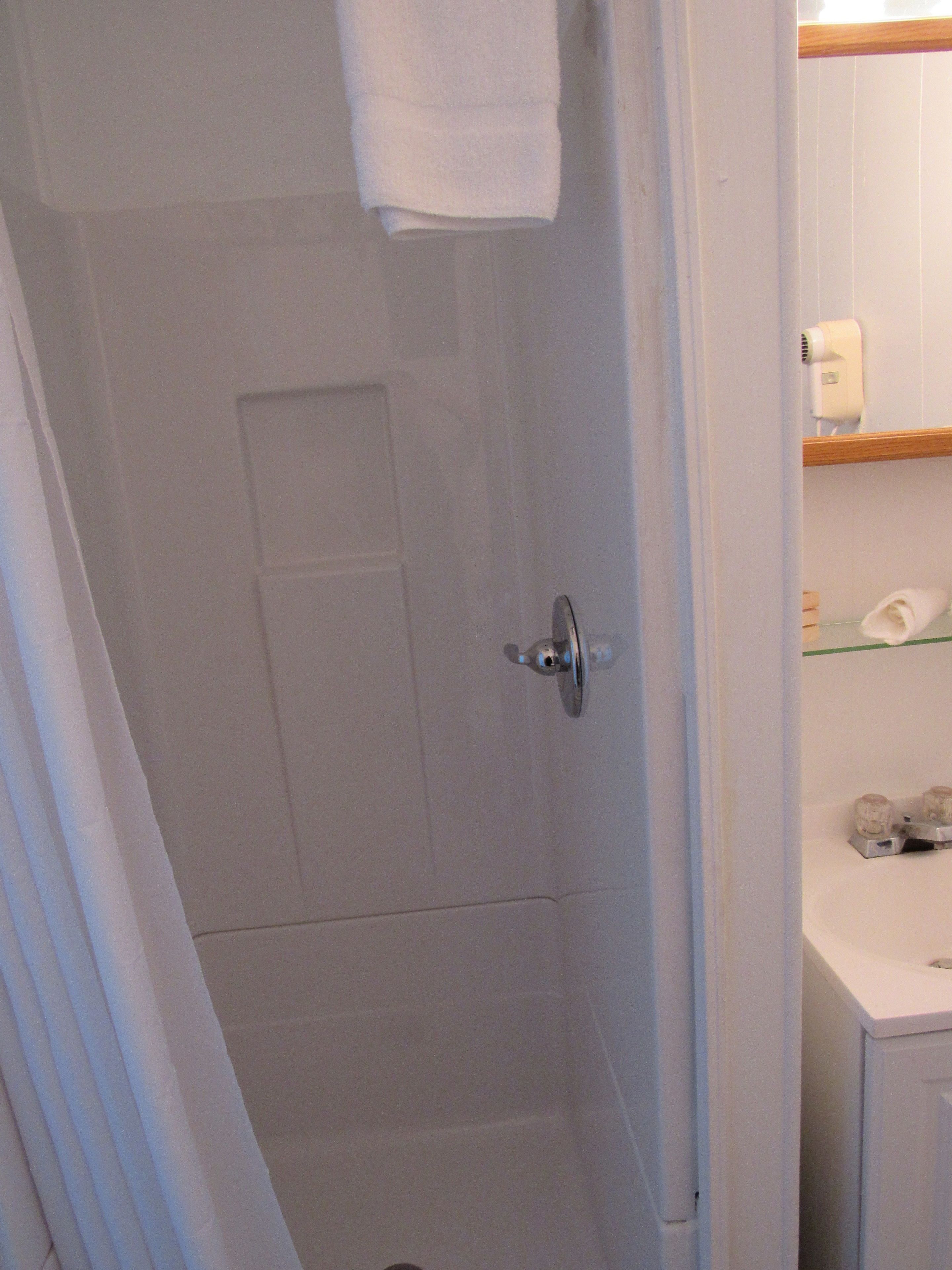 Un bagno con doccia, un water e un lavandino.