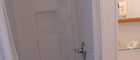 A bathroom with a shower, a toilet, and a sink.