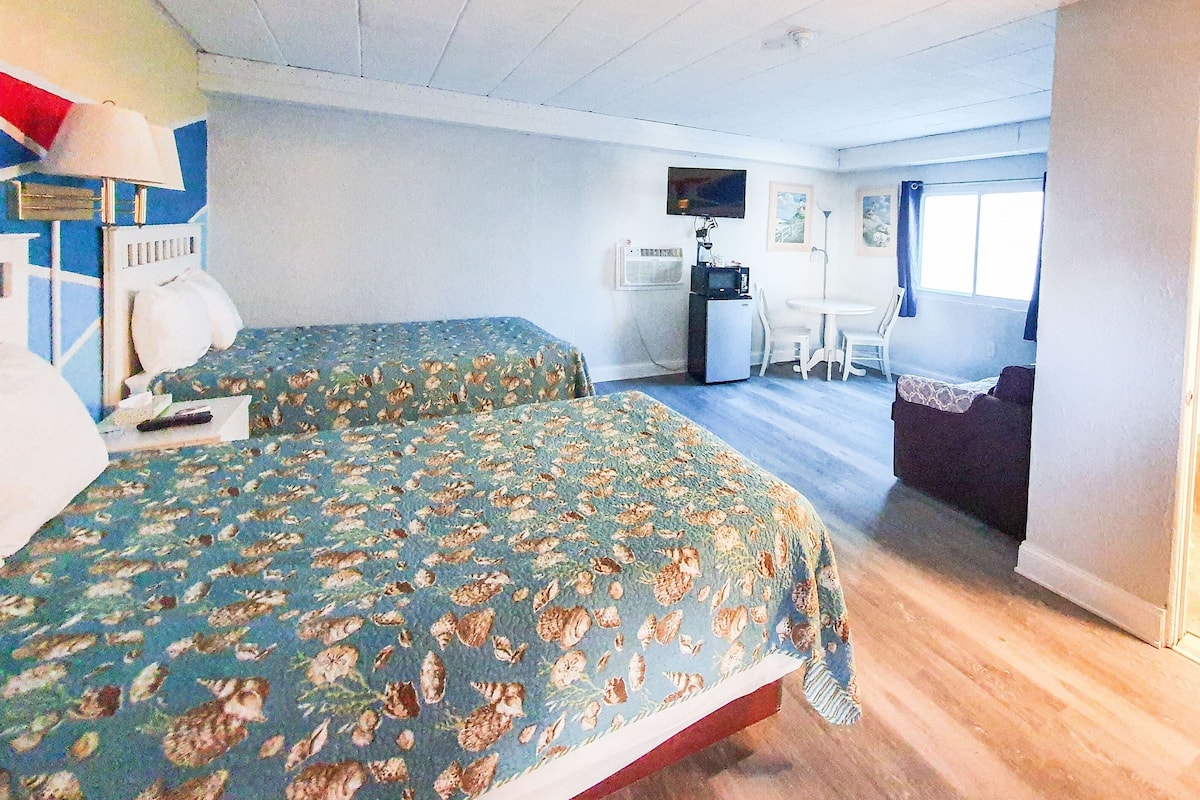 Een kamer met twee bedden, een bureau en een stoel.