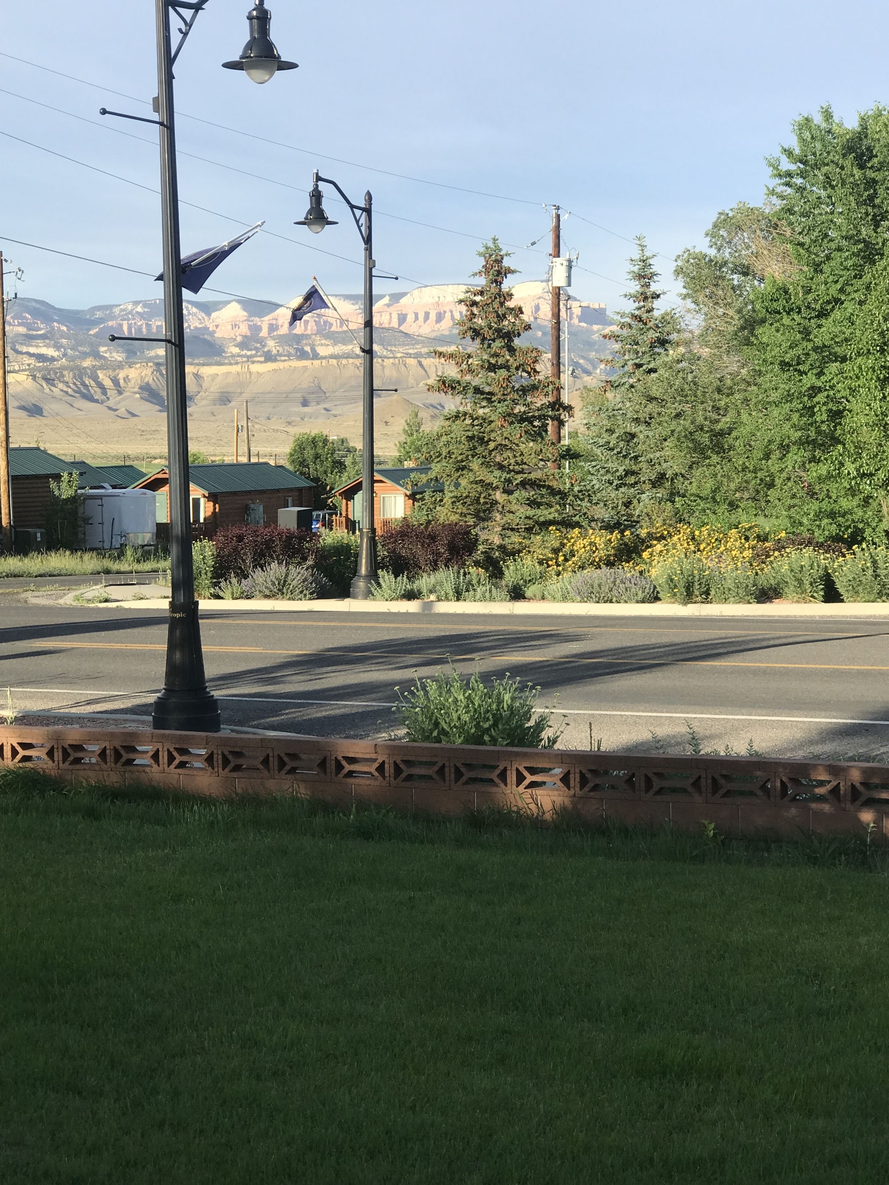 A street with a lamp post, a road, and a mountain range in the background.
