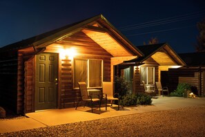 A log cabin with a porch, a door, and a window.