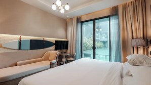 A hotel room with a bed, a sofa, a TV, a small table, and a balcony with a pool view. - Sugar Marina Resort -Surf- Kata Beach (Karon)