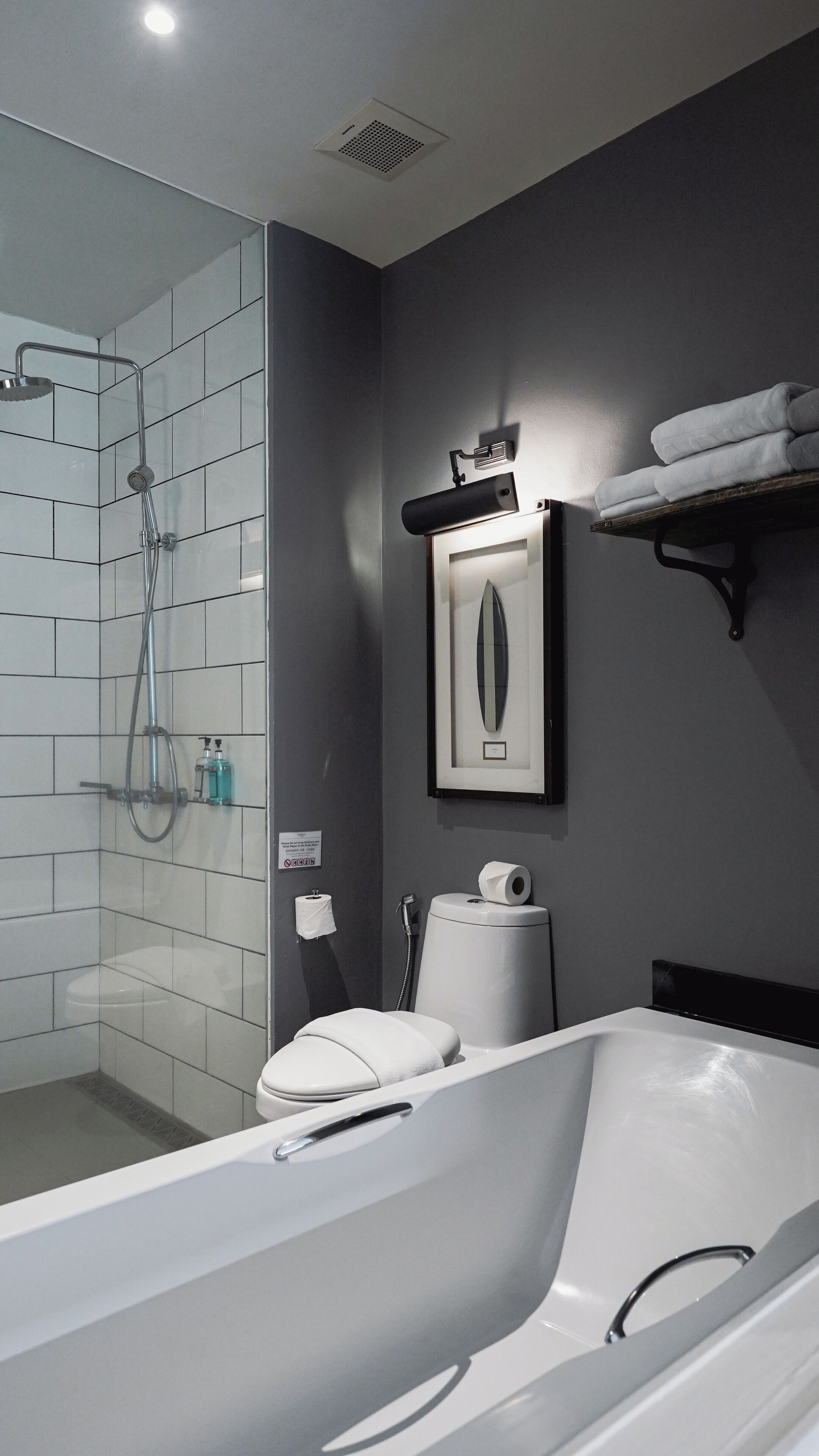 Een moderne badkamer met douche, toilet en bad.