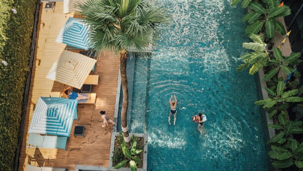An aerial view of a swimming pool with lounge chairs and umbrellas, surrounded by greenery. - Sugar Marina Resort -Surf- Kata Beach (Karon)