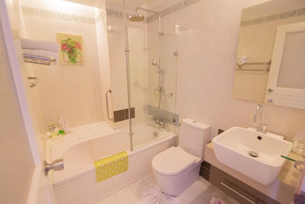 A modern bathroom with a glass-enclosed shower, a bathtub, a toilet, and a sink.