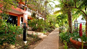 A pathway leading to a building surrounded by lush greenery and tropical plants. - C&N Resort and Spa (Patong)