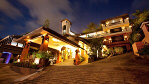A multi-story hotel with a grand entrance, multiple balconies, and a well-lit facade. - C&N Resort and Spa (Patong)