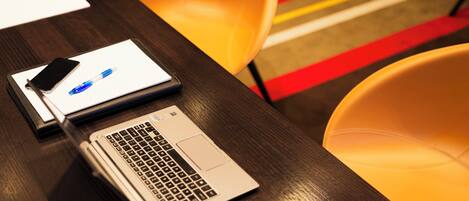A wooden table with a laptop and a smartphone on it.
