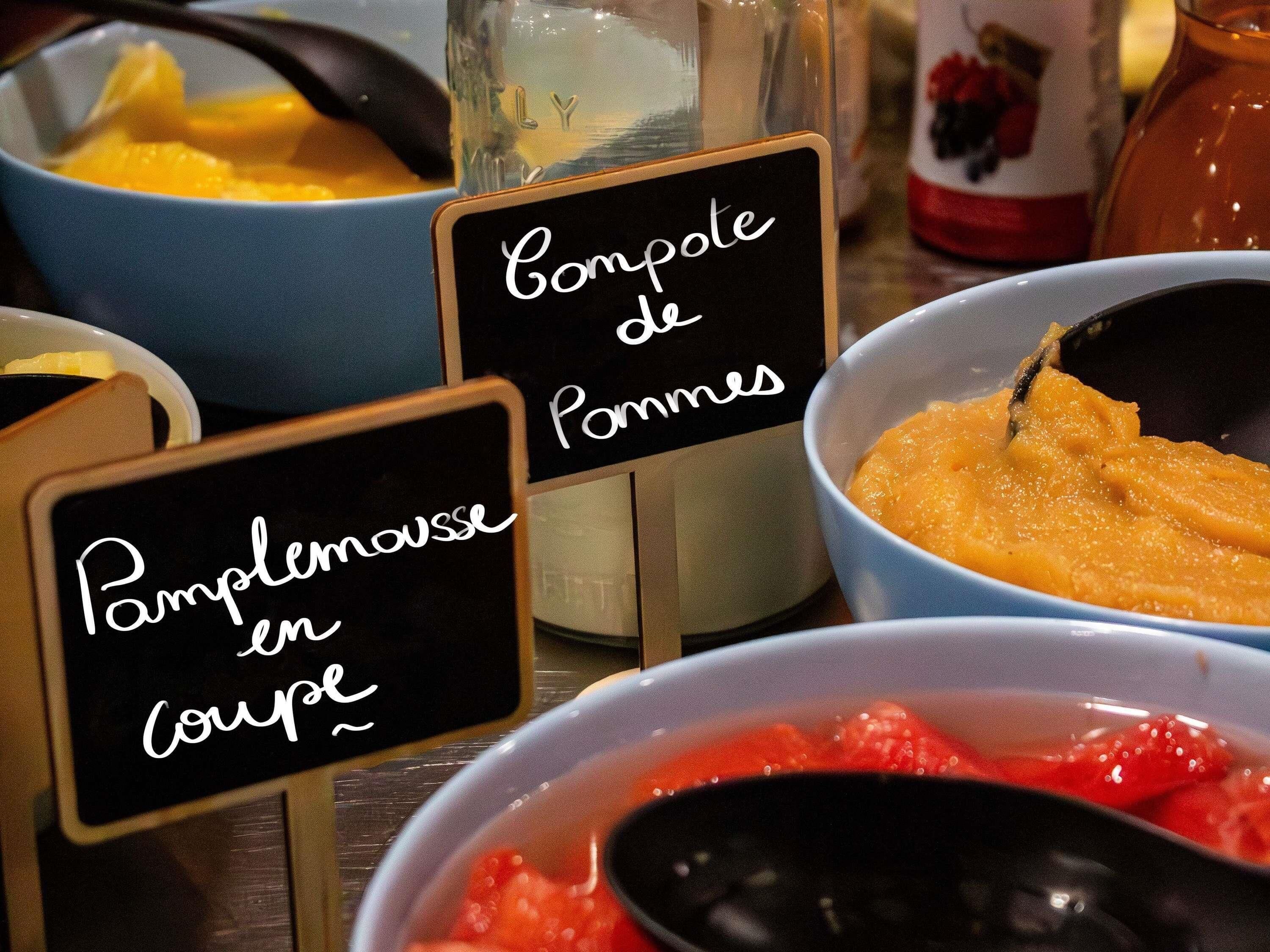 A table with labeled bowls of food, including pomme de terre and pomme de terre en coupe.
