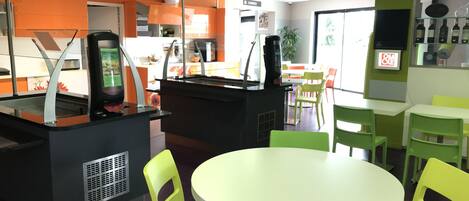 A restaurant with a counter, chairs, and tables.