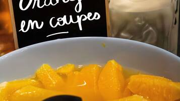 A bowl of orange slices with a sign reading 'Oranges en coupes.'