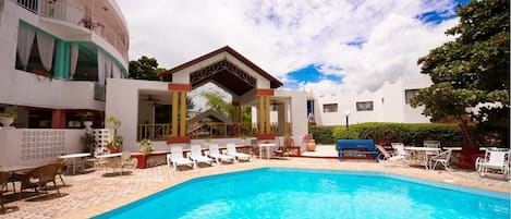 Una piscina al aire libre, tumbonas